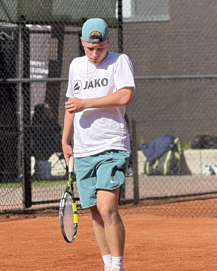 Matteo on a clay tennis court, racket in hand
